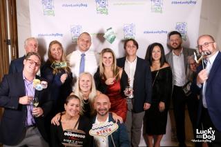 Group of gala attendees in front of the lucky dog step and repeat