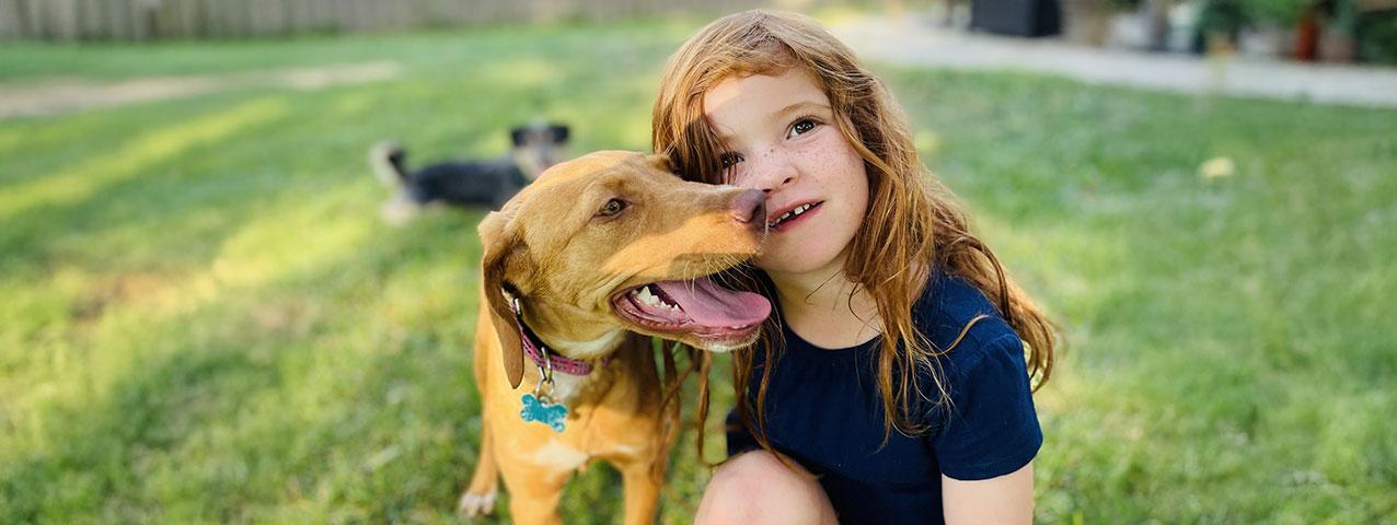 child with rescue dog in yard