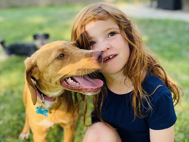 child with rescue dog in yard