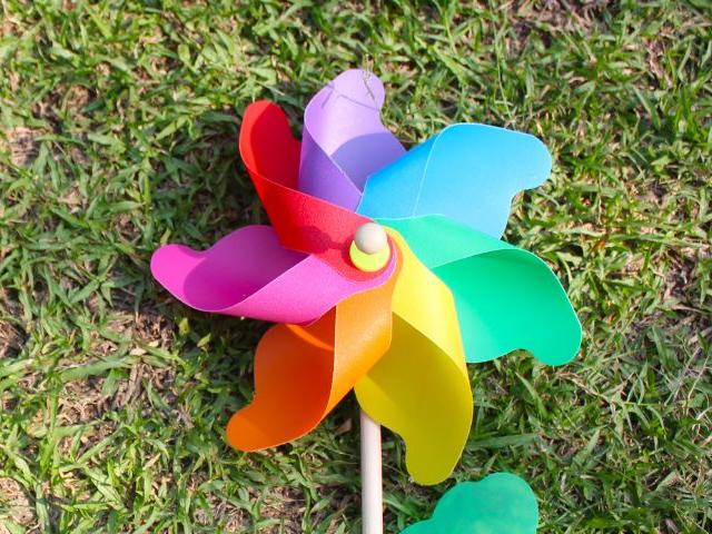 A rainbox pinwheel on a green lawn