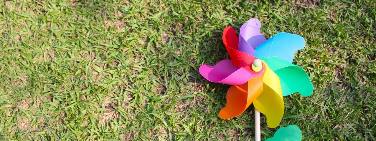A rainbox pinwheel on a green lawn