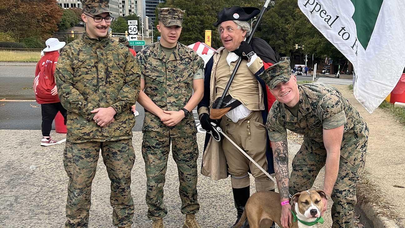 Men in uniform standing with a dog