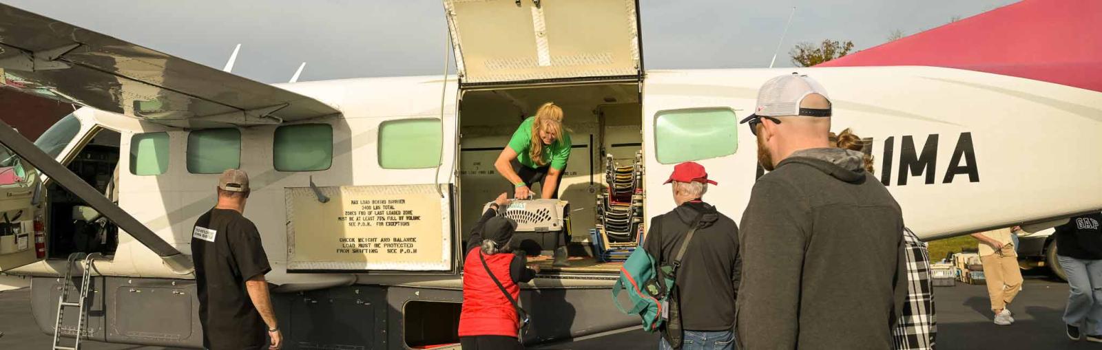 Mirah Horowitz unloading a dog crate from the back of a plane