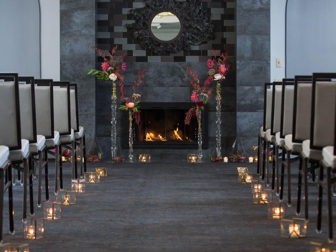 Chairs on the right and left with a candle lit aisle down the center.