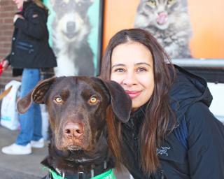 Woman with brown rescue dog at an adoption event.